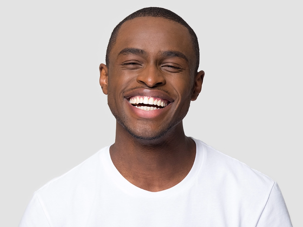 cheerful happy millennial man laughing looking at camera
