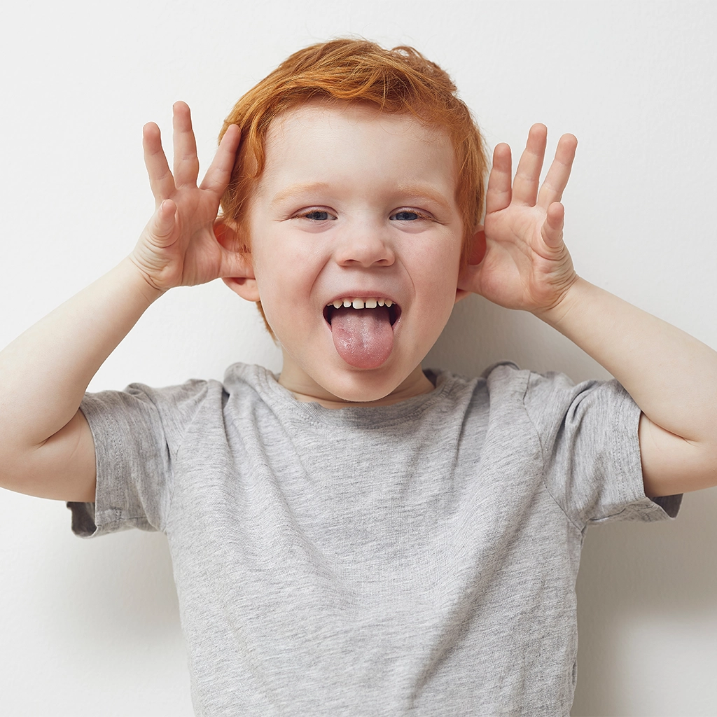 redhead child and boy being silly and having fun in front of camera