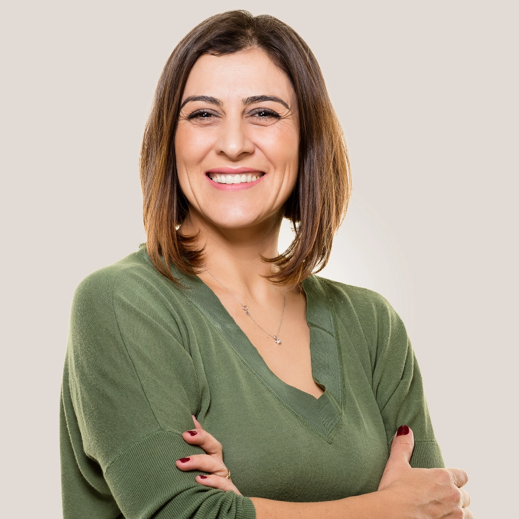 smiling happy woman with arms crossed on light color