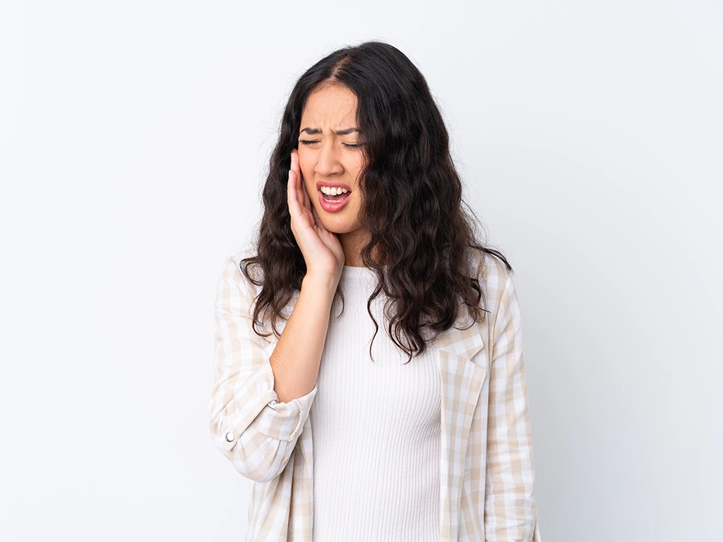 woman holding side of mouth in pain toothache